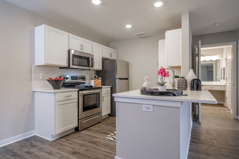 a kitchen with white cabinets and stainless steel appliances at Saw Mill Village apartments