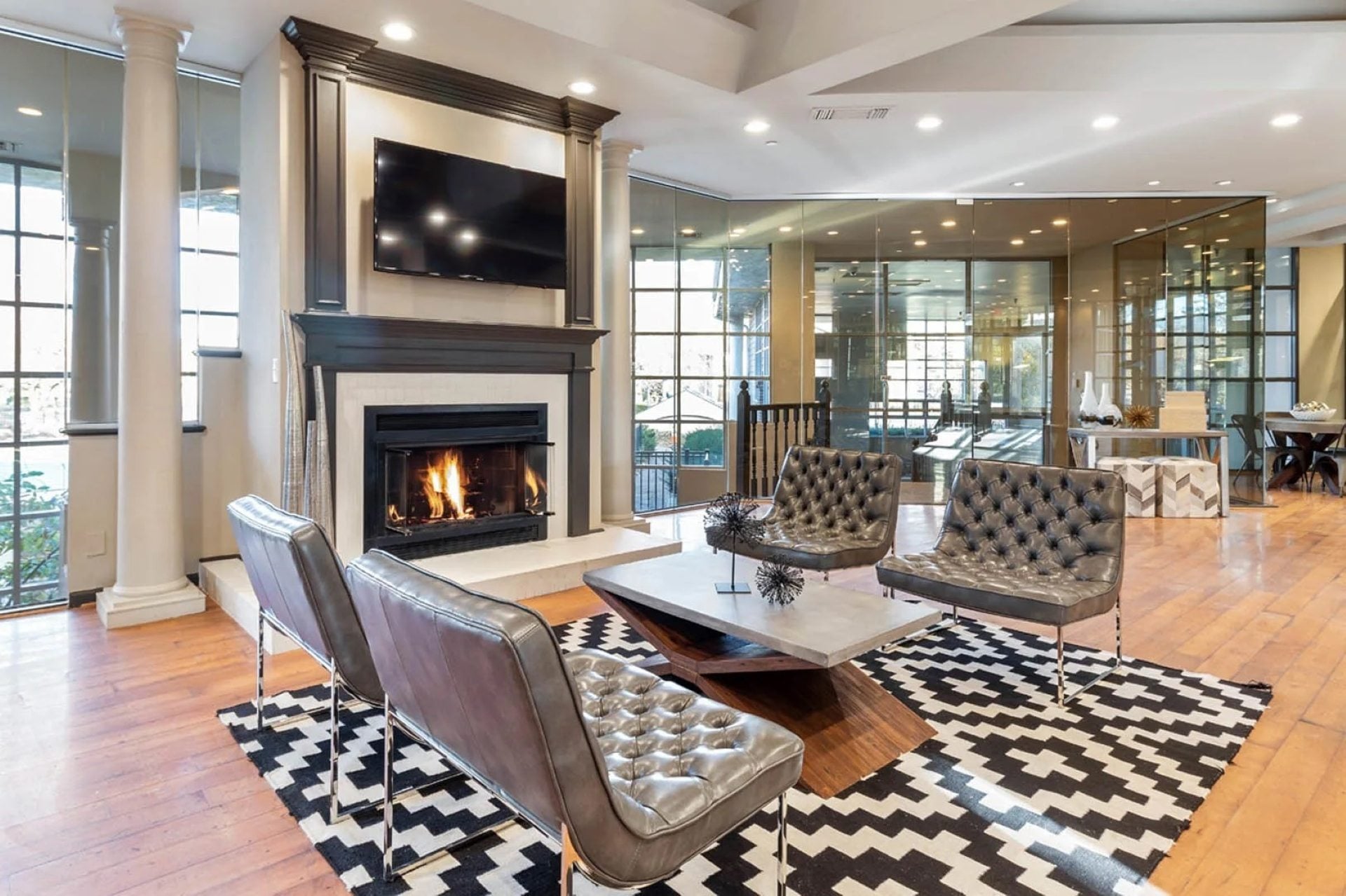 A living room with a fireplace and a television mounted above it.