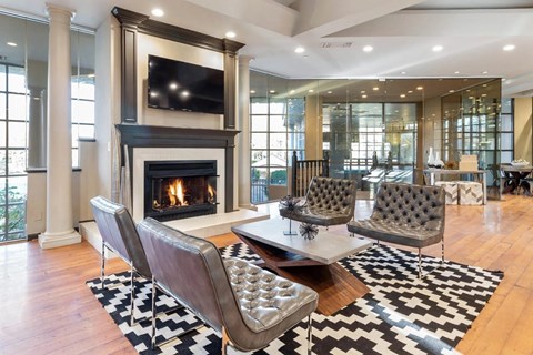 A living room with a fireplace and a television mounted above it.