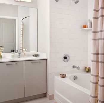 A white bathroom with a white tub and a white sink.