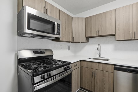 A modern kitchen with a stainless steel oven and microwave.