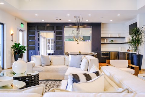 A modern living room with white furniture and a large window.