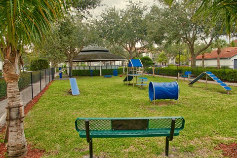 A playground with a green bench and a blue slide.