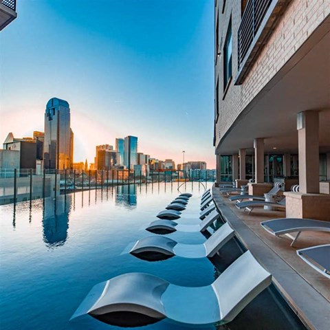 an infinity pool with a Dallas skyline view at The Gabriella apartments