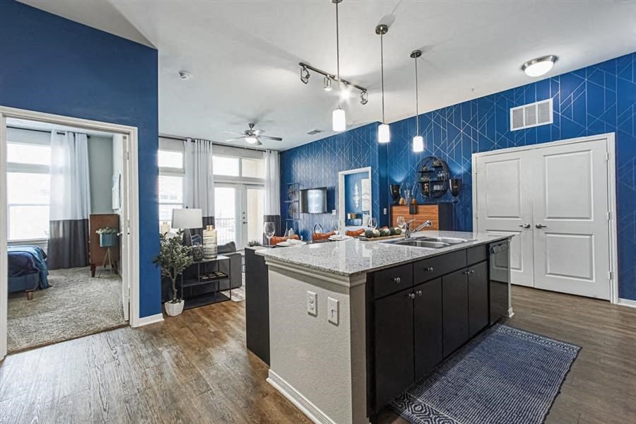 Open concept kitchen with designer lighting at Aspire at 610 apartments in Houston, TX