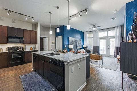 Kitchen with kitchen island and granite countertops and open-concept living area at Aspire at 610 apartments