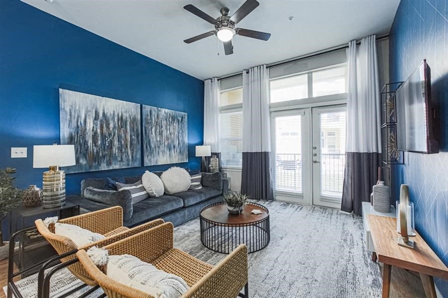 Spacious living room with ceiling fain and expansive windows at Aspire at 610 apartments