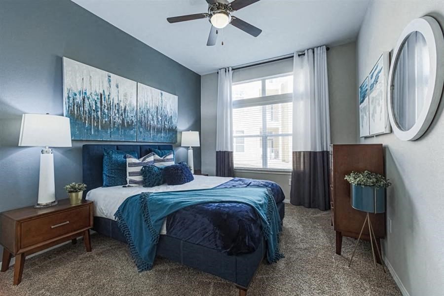 bedroom with ceiling fan and expansive windows at Aspire at 610 apartments