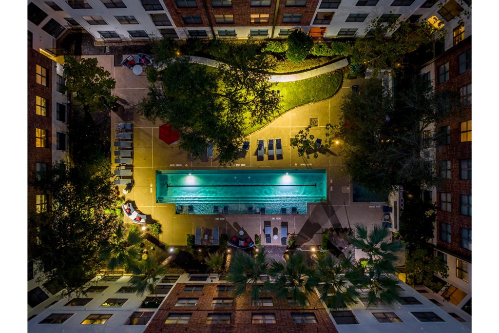 an aerial, night-time view of the swimming pool at The Core apartments
