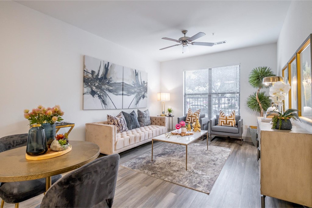 a living room with a ceiling fan and expansive windows at The Core apartments