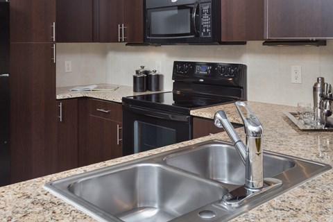 A kitchen with a black oven and microwave.