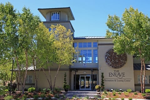 The Enave Recreation and Leasing Center is a large, modern building with a circular logo on the front.
