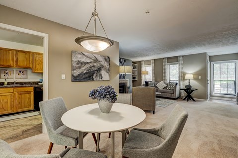 A modern dining room with a round table and chairs.