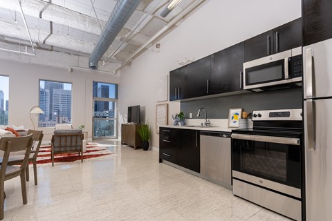 A kitchen with black cabinets and stainless steel appliances.
