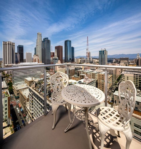 A patio table and chairs overlooking a city skyline.