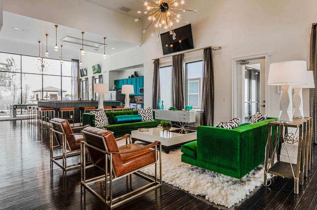 A living room with a green couch and a white rug.