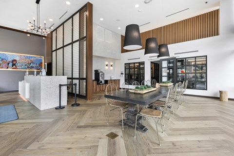 A modern dining room with a long table and chairs.