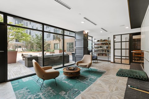 A living room with a green rug and a chair.