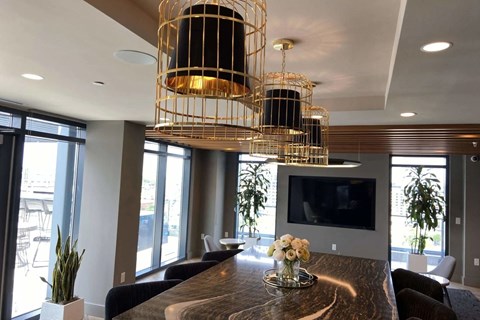 A modern dining room with a wooden table and a television mounted on the wall.