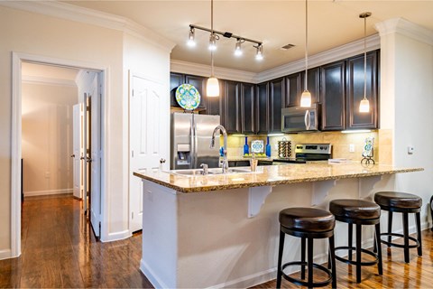 a kitchen with a bar and black cabinets