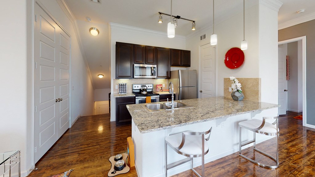 a kitchen with a large island with granite countertops