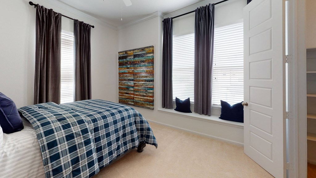 a bedroom with a bed and three windows