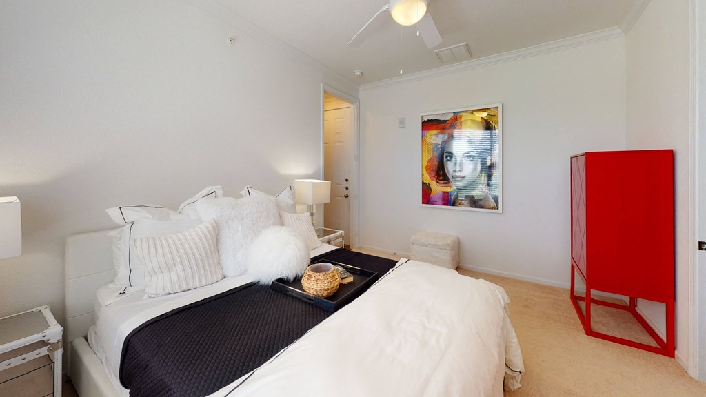 a bedroom with a bed and a painting on the wall