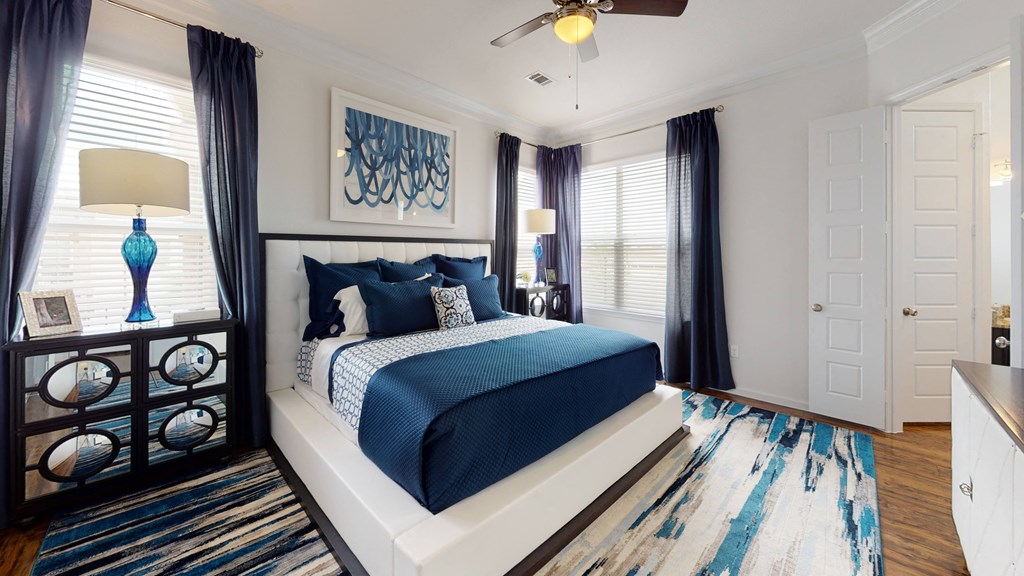 a bedroom with a bed and two windows