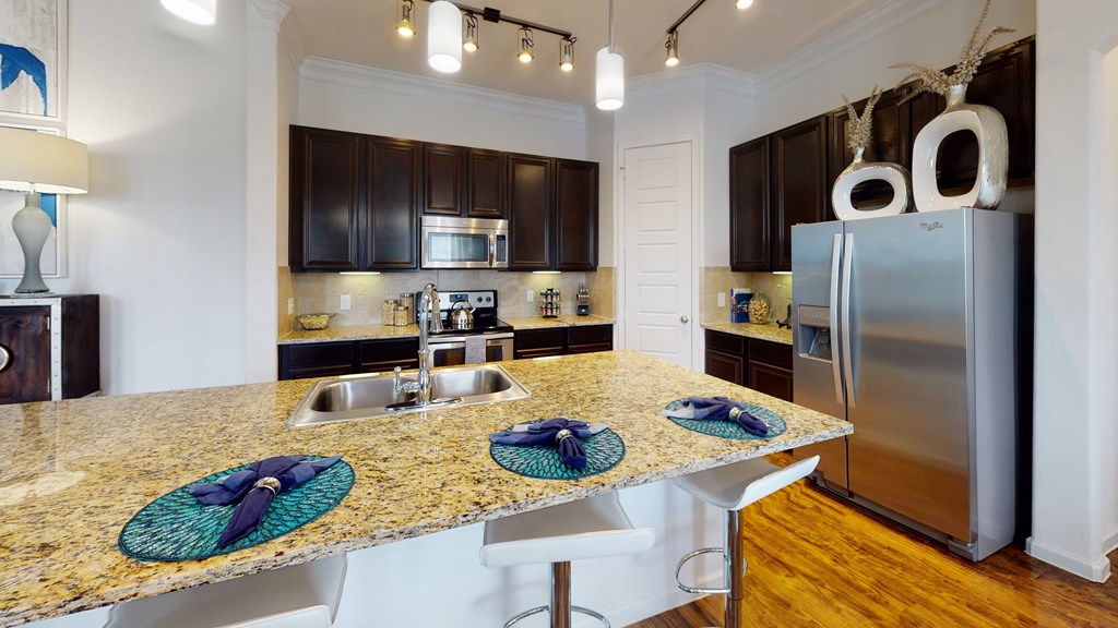 a kitchen with granite countertops and stainless steel appliances