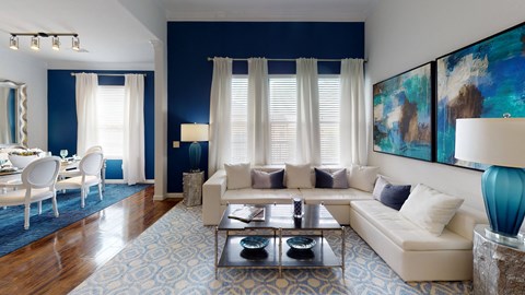 a living room with blue walls and white furniture and a blue rug