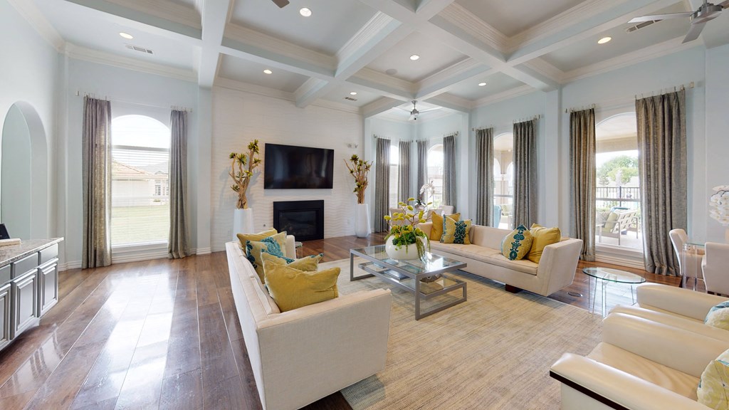 a living room with a coffered ceiling and hardwood flooring