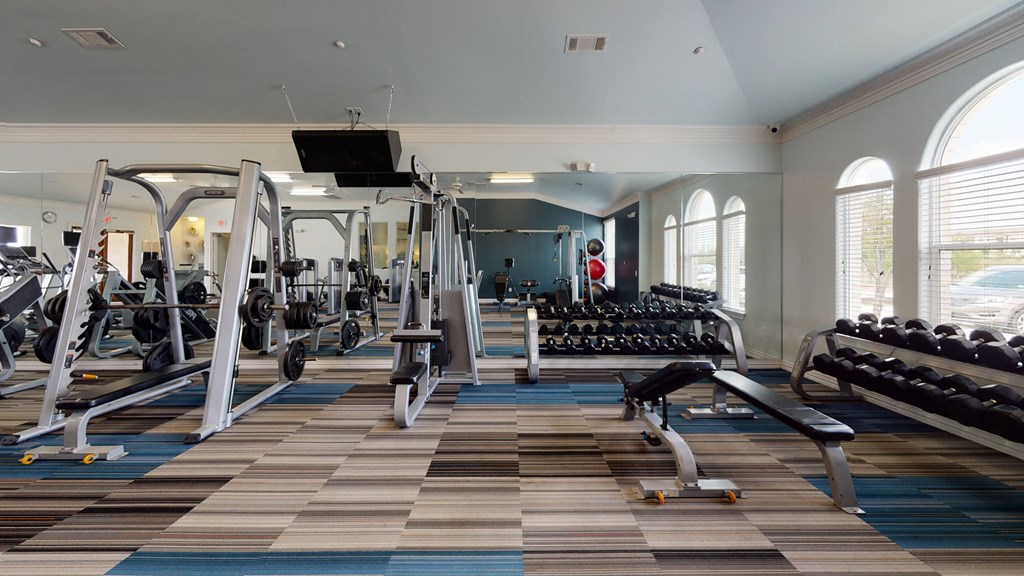 a large fitness room with treadmills and other exercise equipment