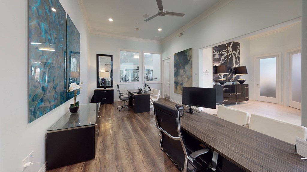a home office with white walls and hardwood flooring