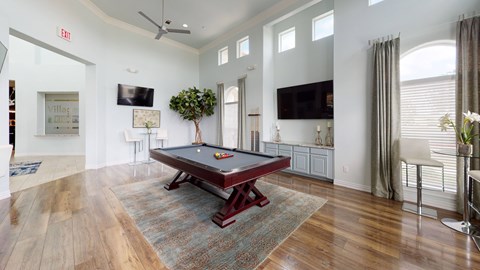 A room with a pool table and a tv.