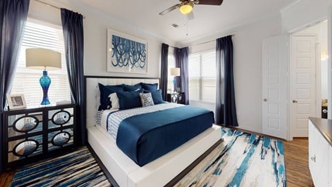 A bedroom with a large bed and a ceiling fan.