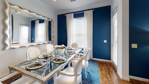 A dining room with a glass table and white chairs.