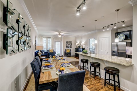A dining room with a table set for a meal.