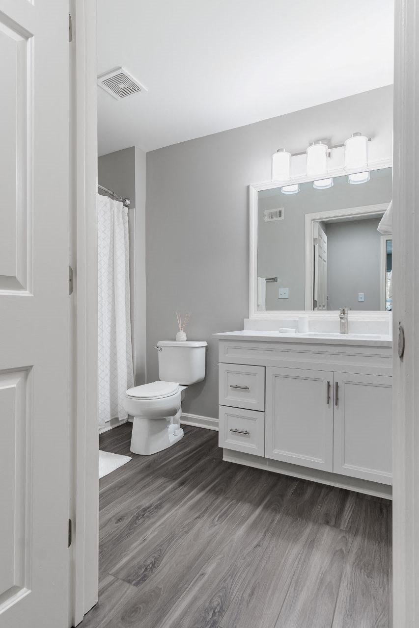 bathroom with white cabinetry and designer lighting at Ellington Metro West apartments