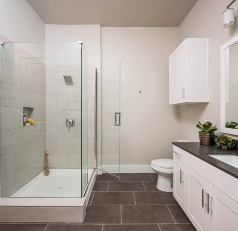 spacious bathroom with glass framed shower doors at Tinsley on the Park apartments