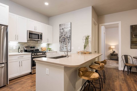 a kitchen with custom cabinetry and stainless steel appliances at Tinsley on the Park apartments