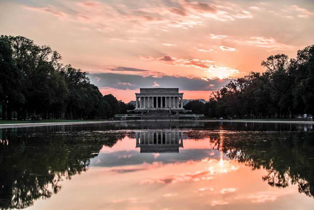 a sunset over the reflecting pool at the memorial