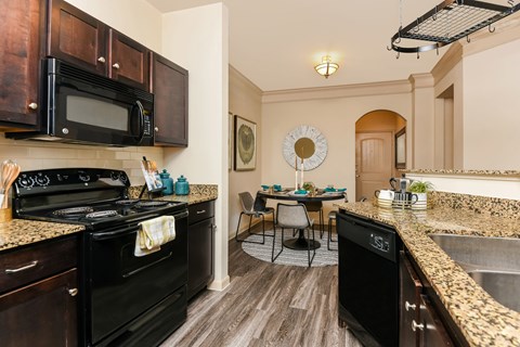 A kitchen with black appliances and wooden cabinets.