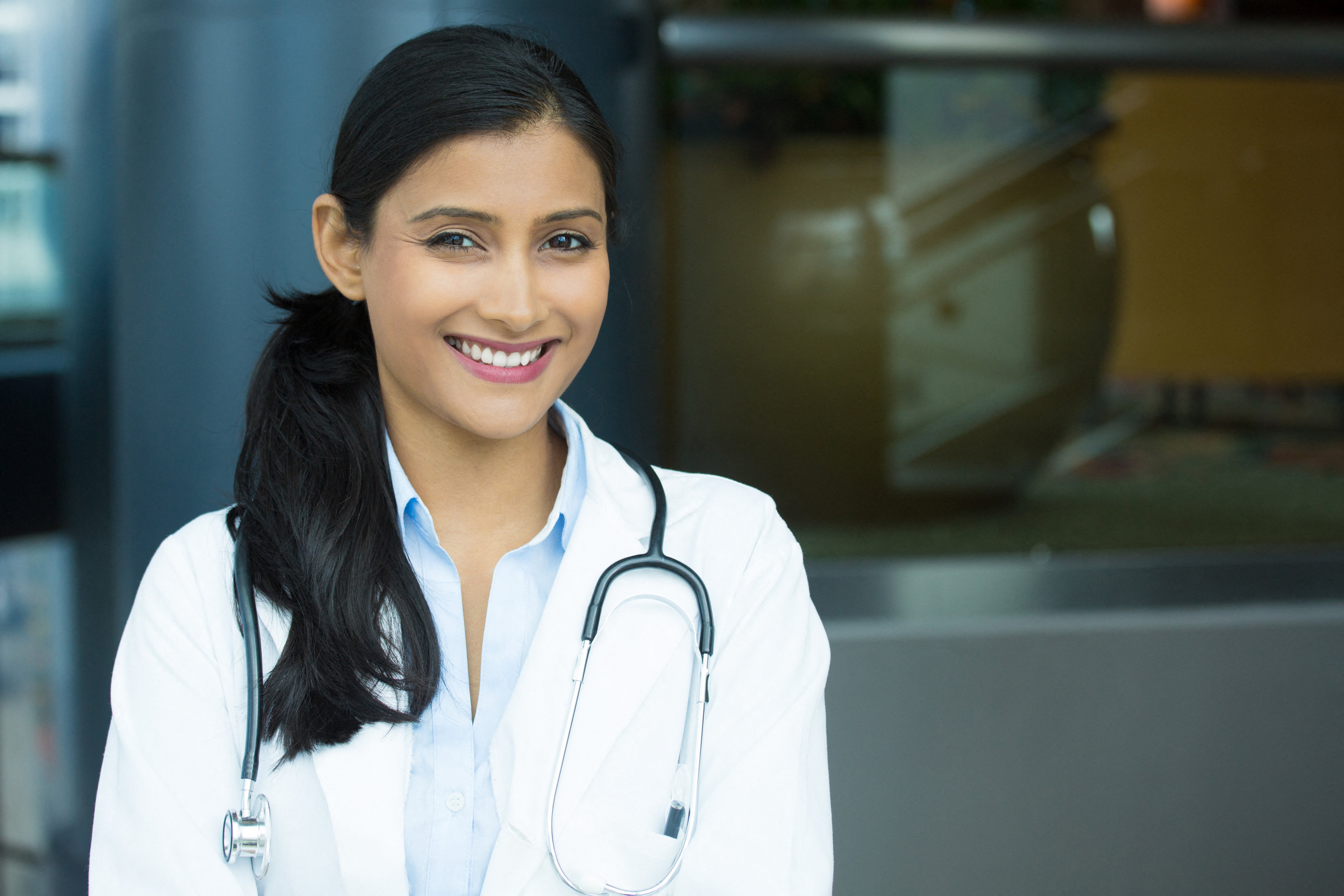 Woman doctor wearing a white coat smiling