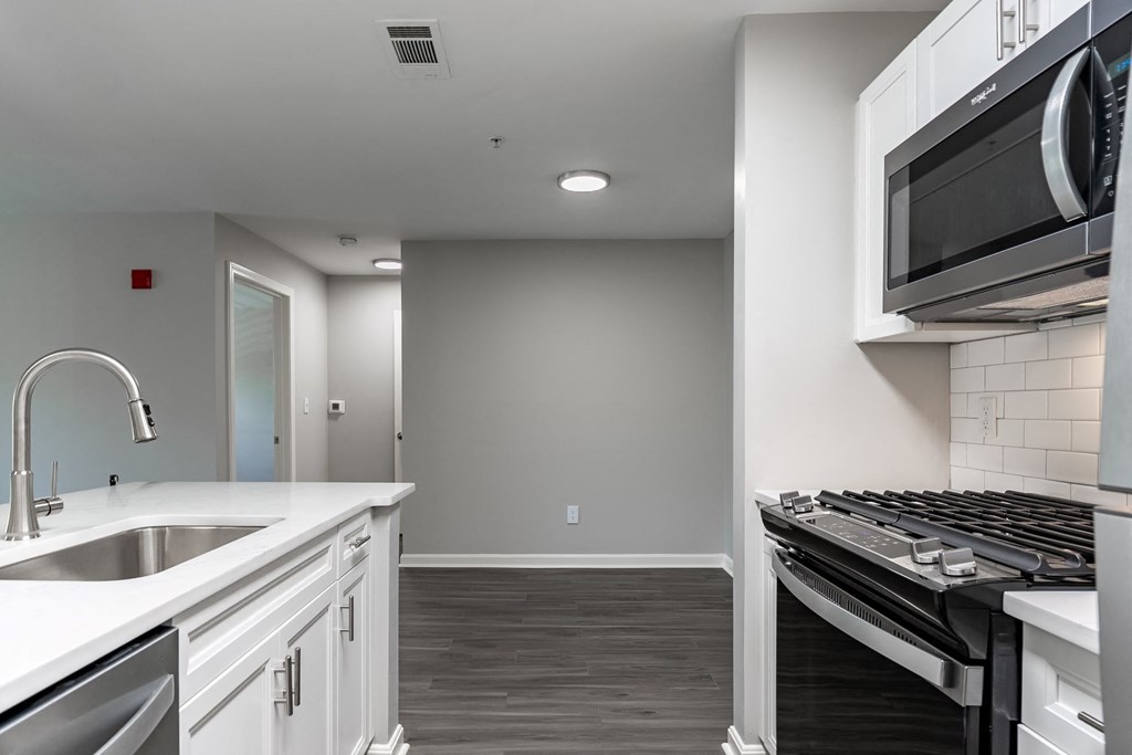 kitchen with white cabinets and high-end appliances at Ellington Metro West apartments