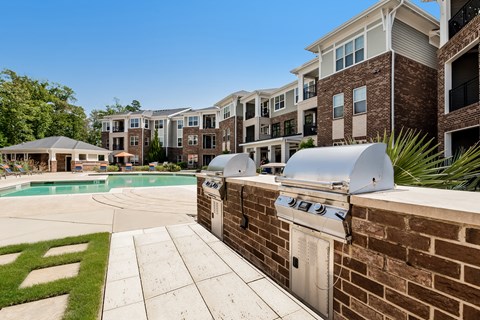 Apartment complex with a pool and BBQ grill.
