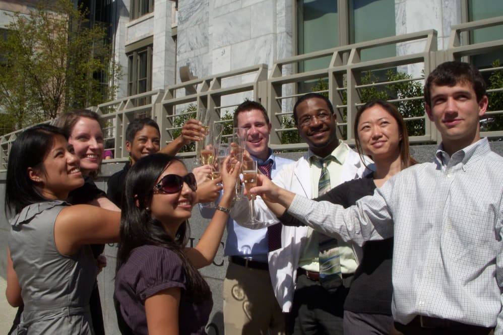 group of young professionals cheering with champagne flutes