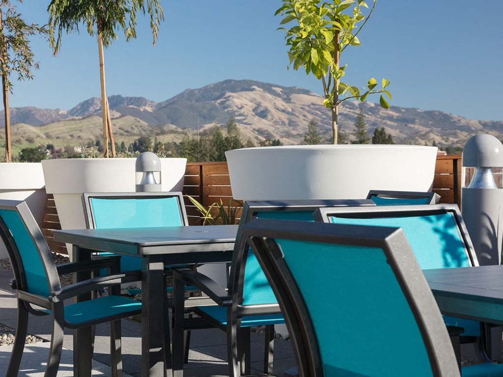 Outdoor common area with chairs and cafe tables at Lyric, Walnut Creek, 94596
