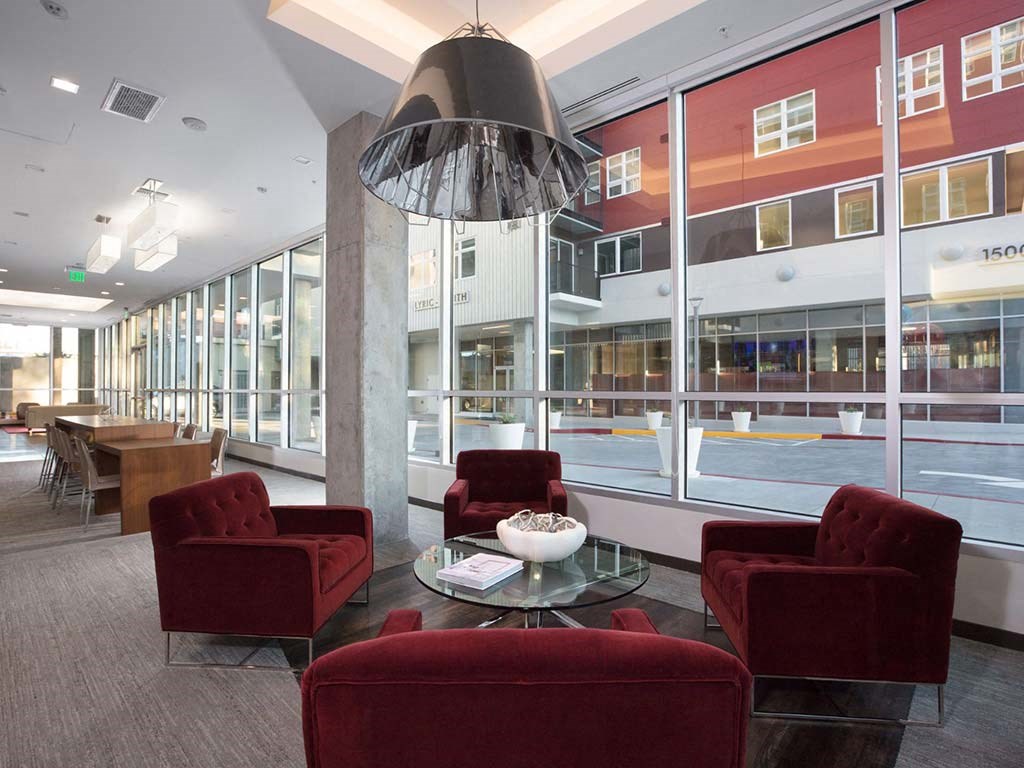Indoor common area with red armchairs at Lyric, California