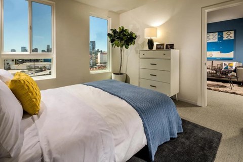 A bedroom with a large bed and a view of the city.