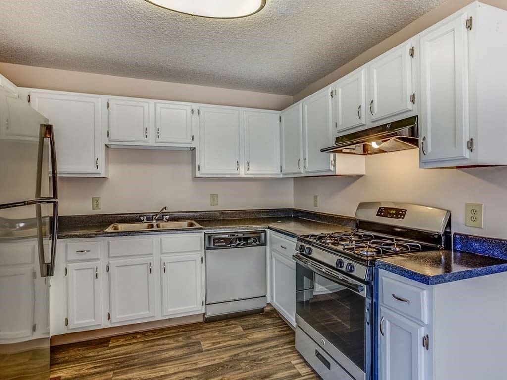 a kitchen with white cabinets and stainless steel appliances